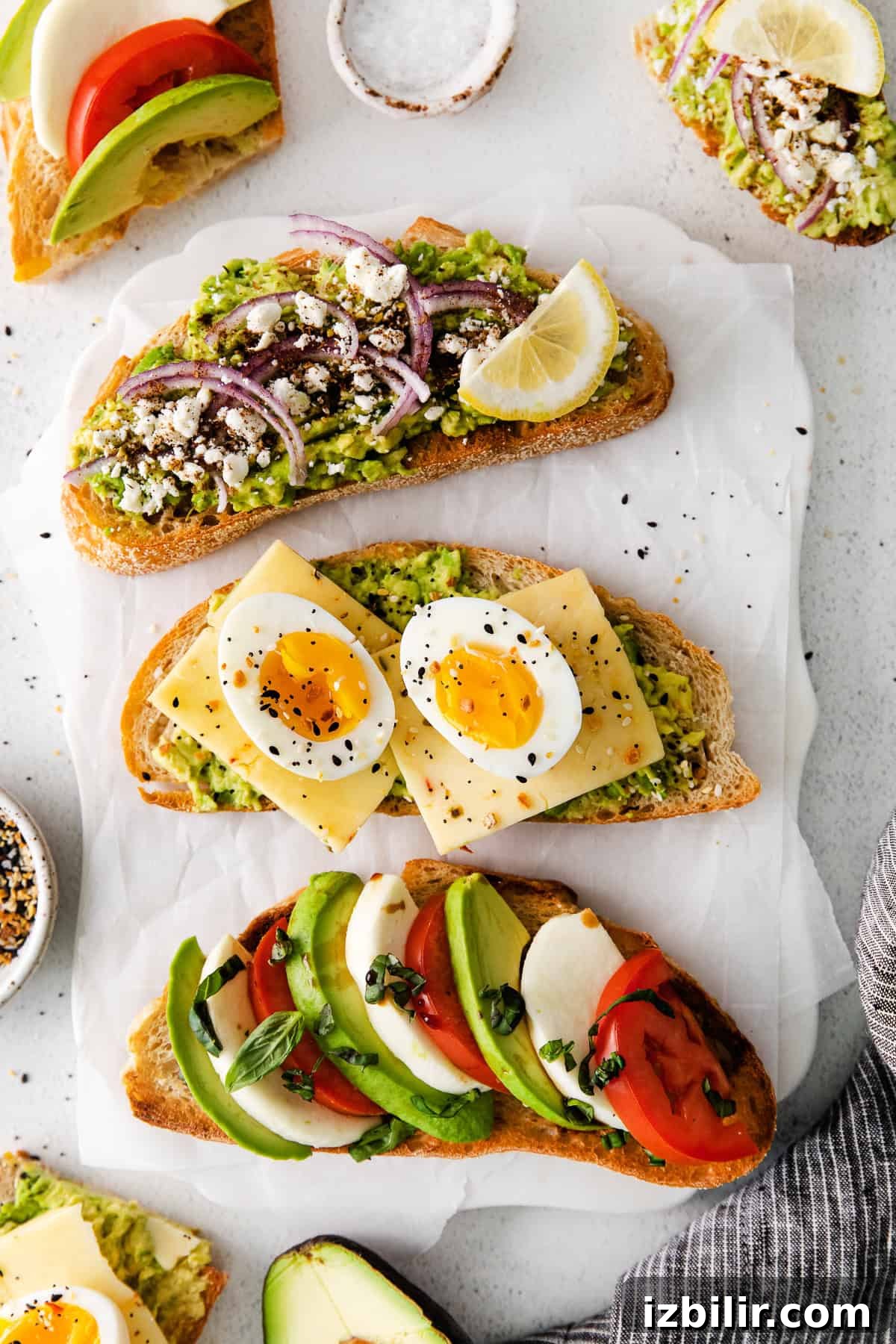 Avocado toast in 3 delicious varieties! We're sharing a Mediterranean, Caprese and a twist on the classic egg on avocado toast that can all be made quickly and easily in your own kitchen. 3 slices of avocado toast on a plate