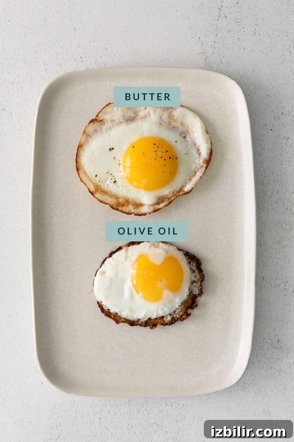 How to Fry an Egg for a Runny Yolk and Crispy Edges 4 An oil fried in butter and an egg fried in oil on a plate.