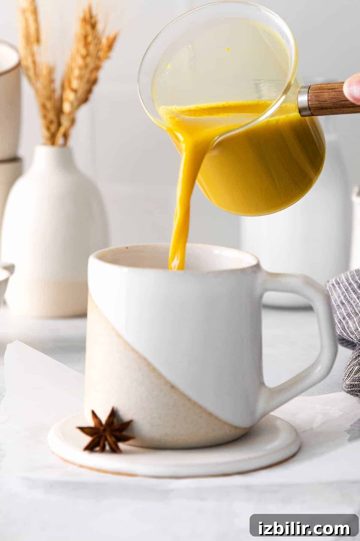 pouring golden milk latte into a glass
