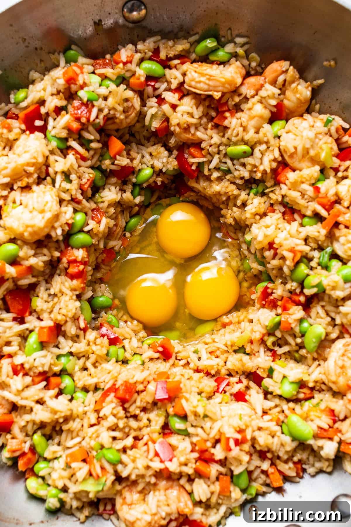 Stirring eggs into fried rice cooking eggs in pan