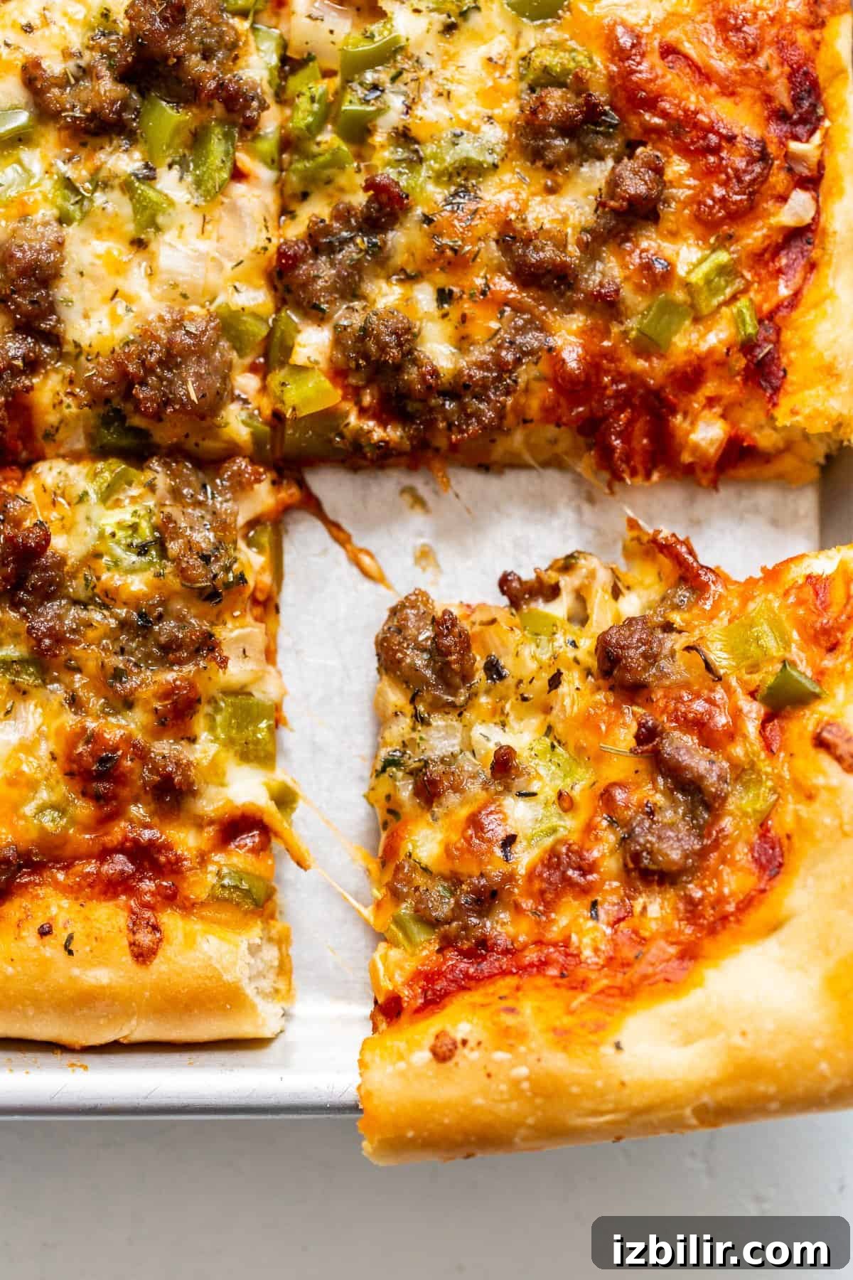 Learn how to make homemade pizza dough from scratch with my Grandma Marie's fool-proof pizza dough recipe! sliced pizza on baking sheet