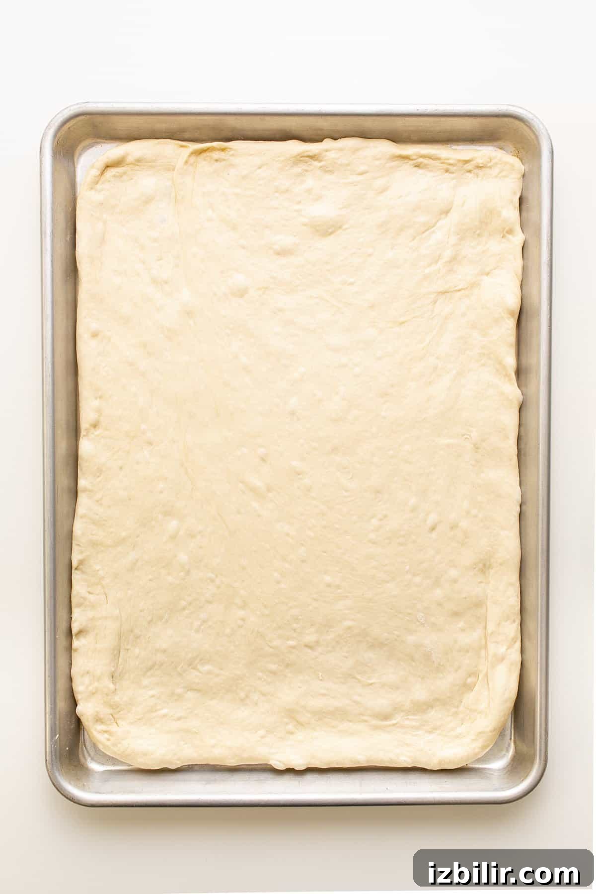 Sheet pan pizza ready to bake pizza dough on baking sheet