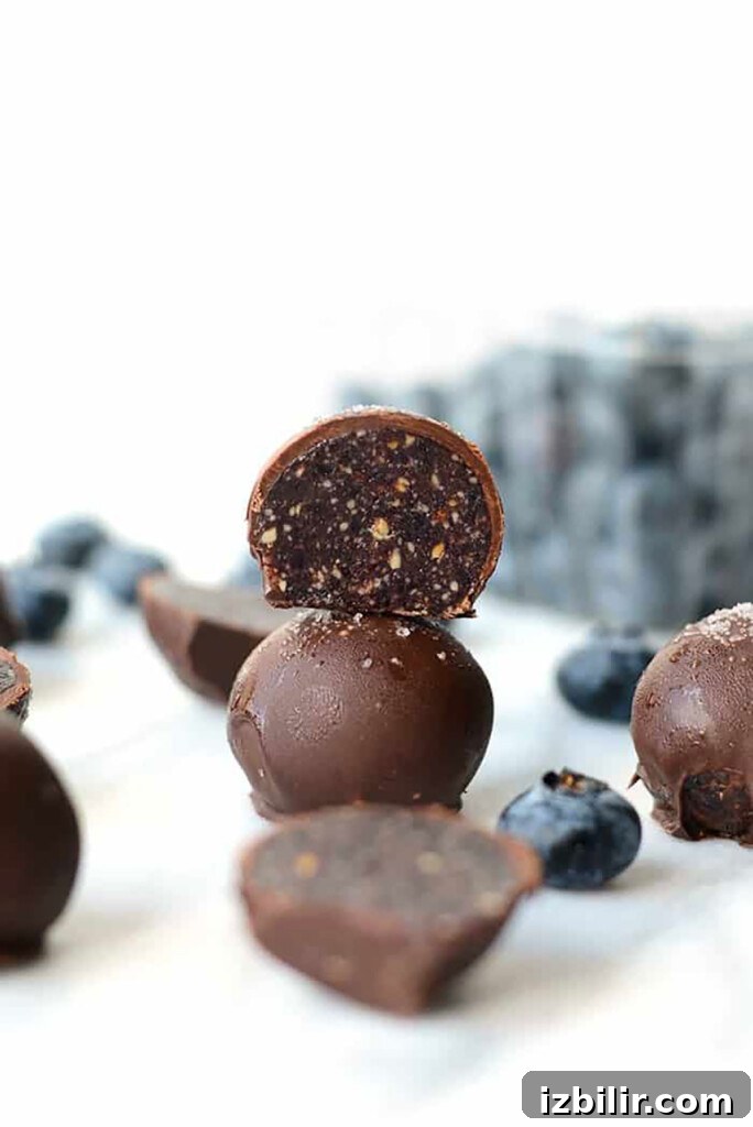 Blueberry truffles on a white surface.