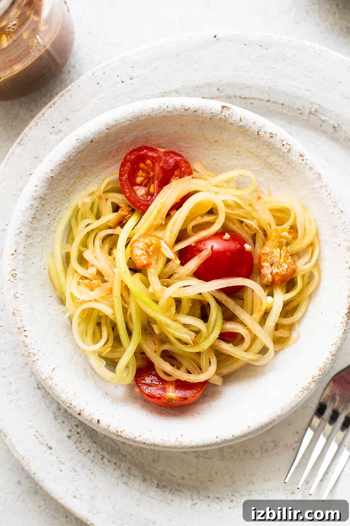 This green papaya salad is light and refreshing with amazing umami flavors. It's inspired by Thai and Lao style papaya salads and is perfect to serve alongside rice and meat dishes. Papaya salad in a bowl.
