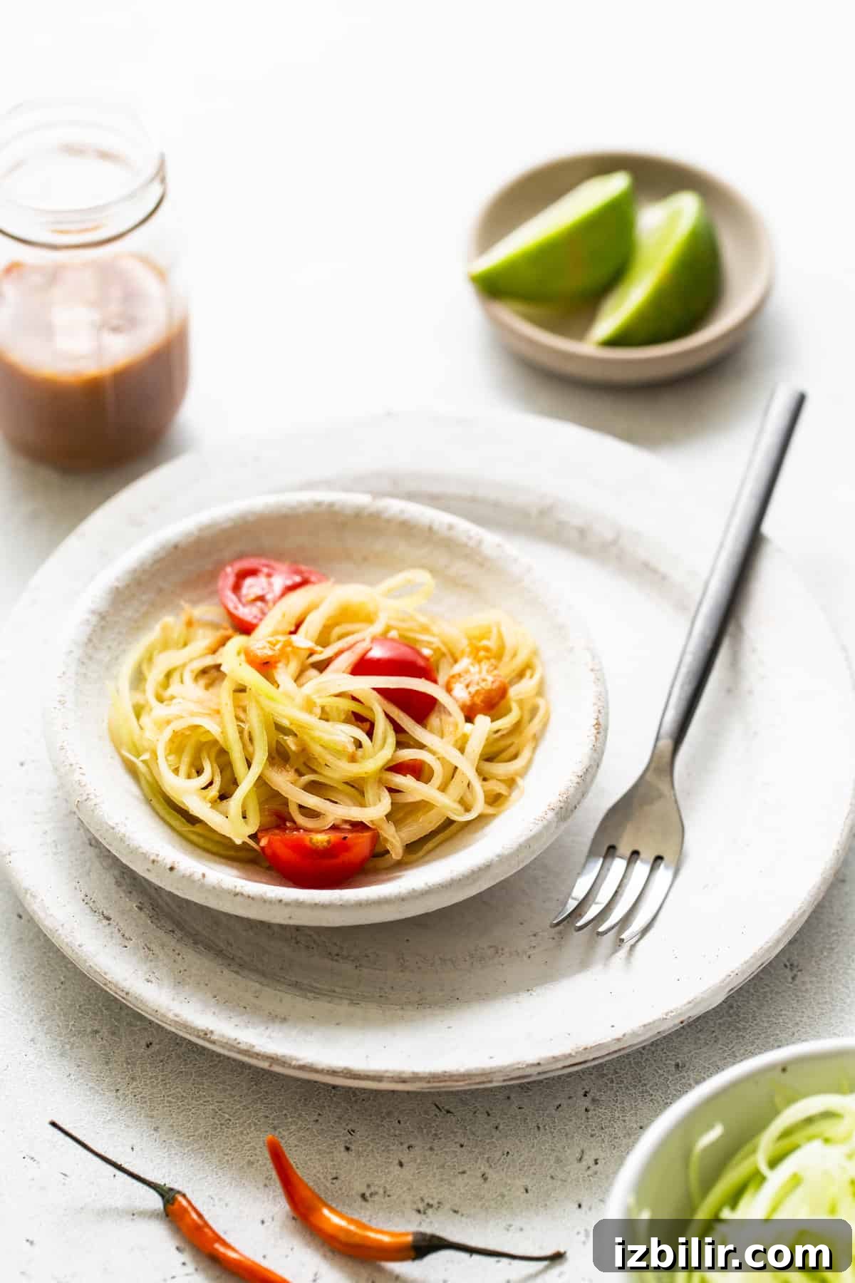 Finished papaya salad ready to serve. Papaya salad in a bowl with a fork.