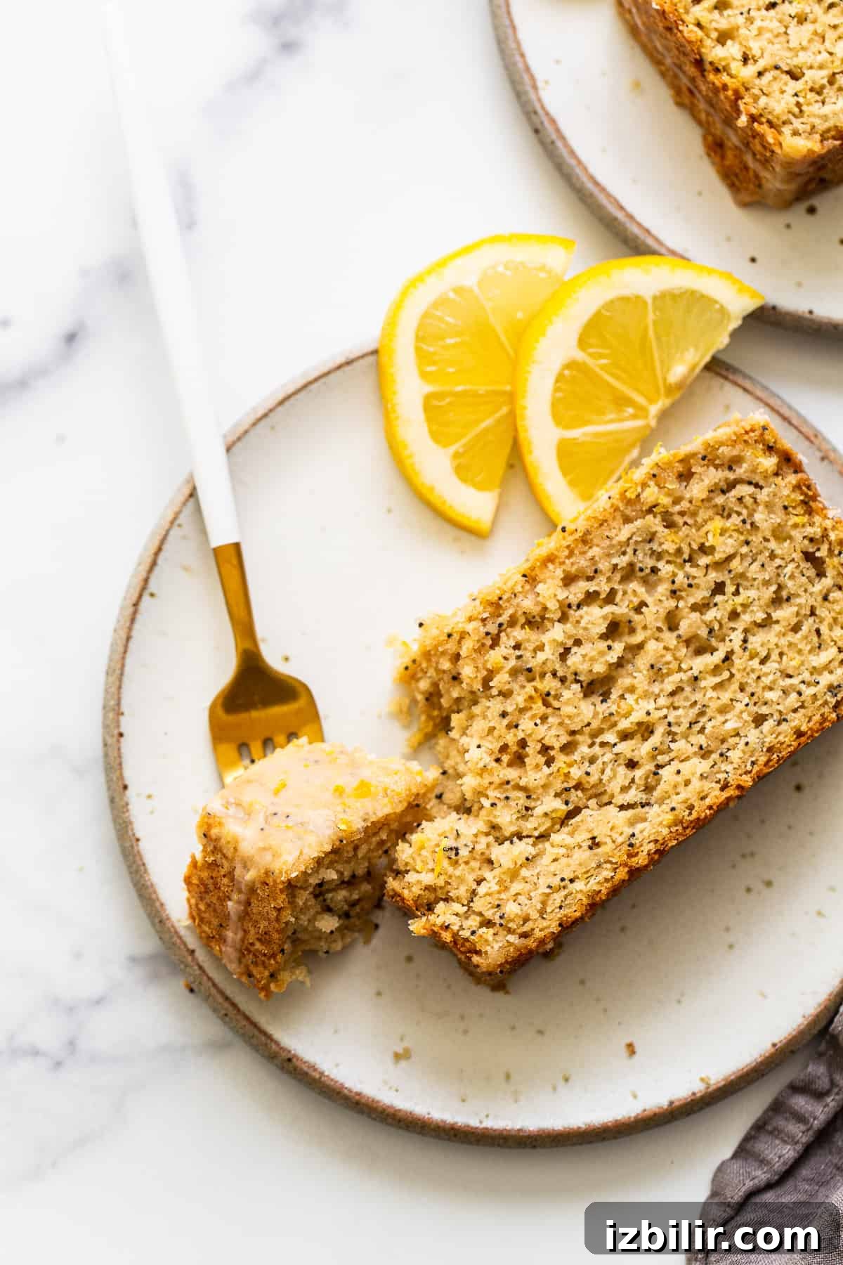 A piece of lemon poppy seed bread on a plate.