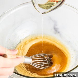 Adding oil to the wet ingredients.
