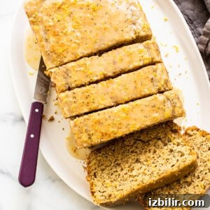A sliced loaf of lemon poppyseed bread on a plate.