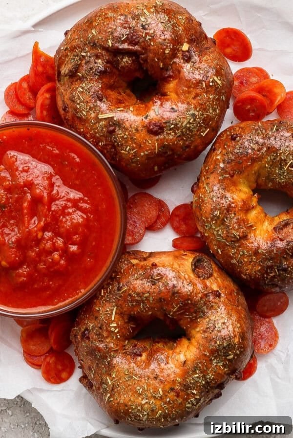 Pizza protein bagels with Italian seasoning served with marinara sauce and pepperoni slices