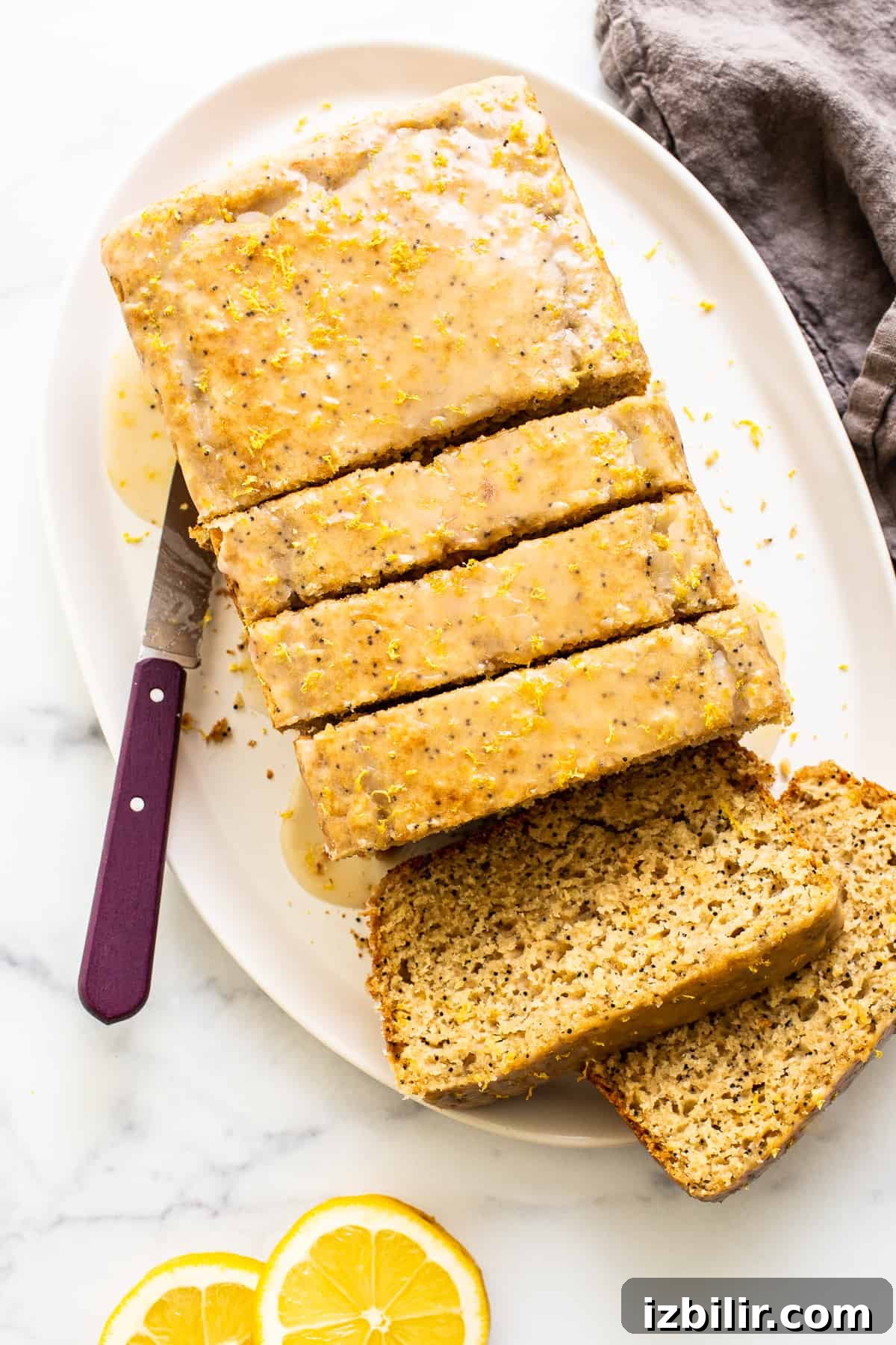 A sliced loaf of lemon poppyseed bread on a plate.