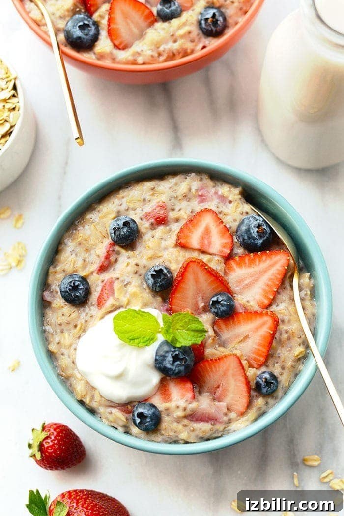 You might mistake this Strawberries and Cream Oatmeal recipe for a sweet treat because it's fresh, flavorful, and tastes just like dessert. oatmeal in bowl with spoon