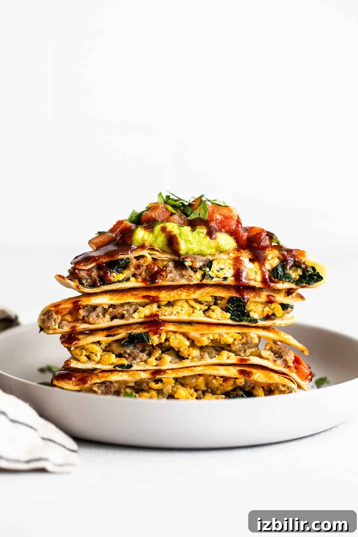 Slices of breakfast quesadillas stacked on a plate.