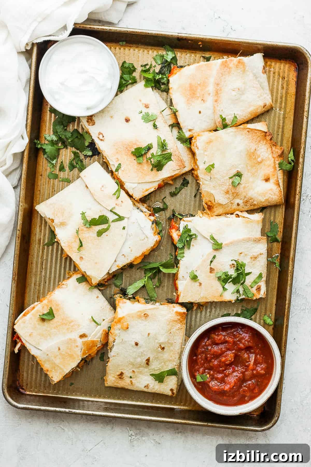 Sheet pan quesadillas that are topped with cilantro.
