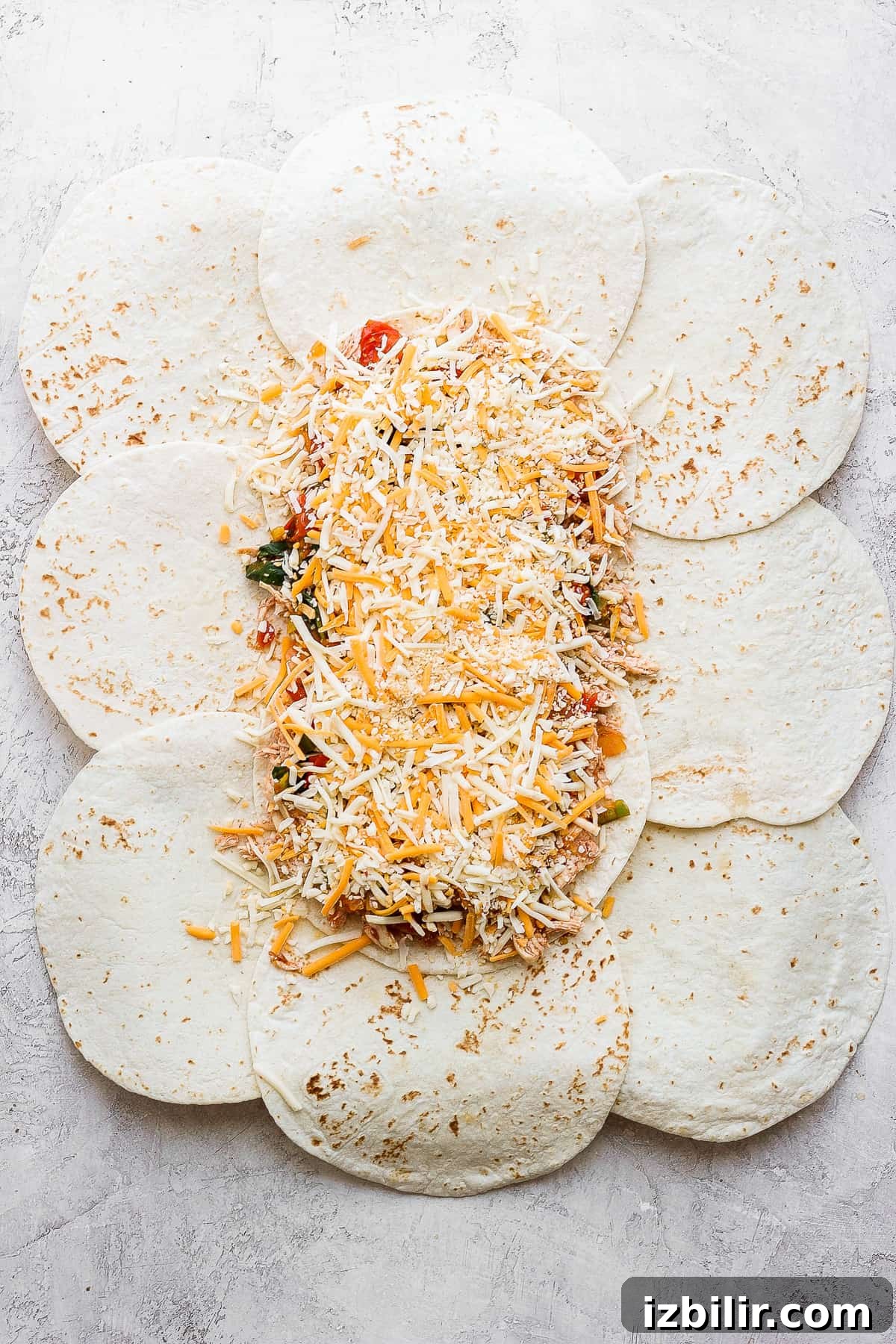 All the toppings for the sheet pan quesadillas on top of the tortillas.