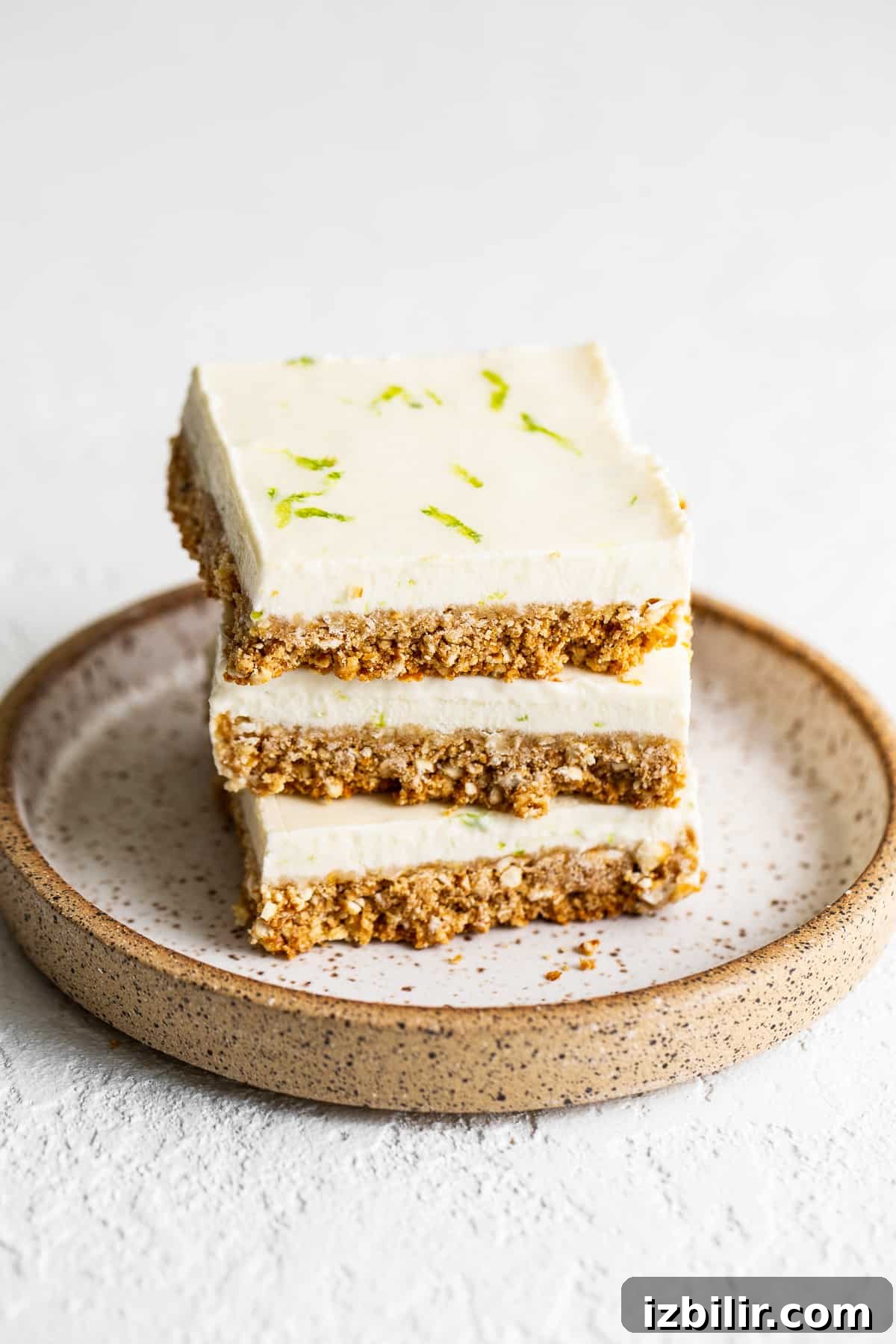 Margarita pie bars are an adult dessert made with a delicious salty crust and a creamy tequila-filled whipped topping. stack of margarita pie bars.