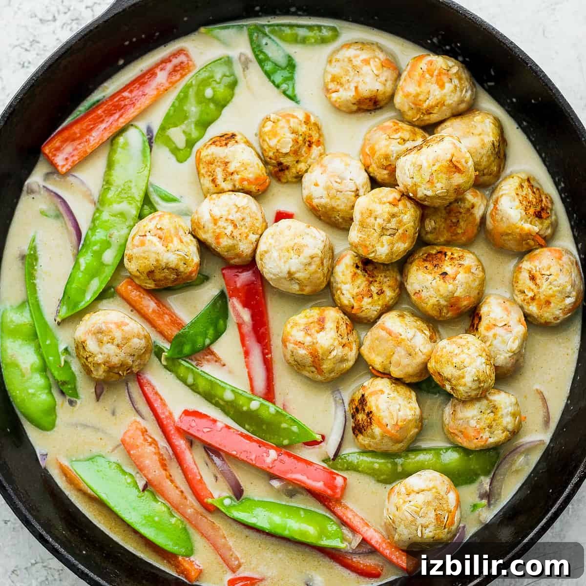 Thai Green Curry Chicken Meatballs 11 Green curry chicken meatballs and vegetables in a cast iron skillet.