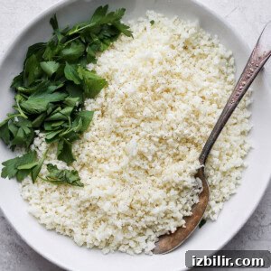 Thai Green Curry Chicken Meatballs 8 A bowl of white rice with parsley and a spoon.