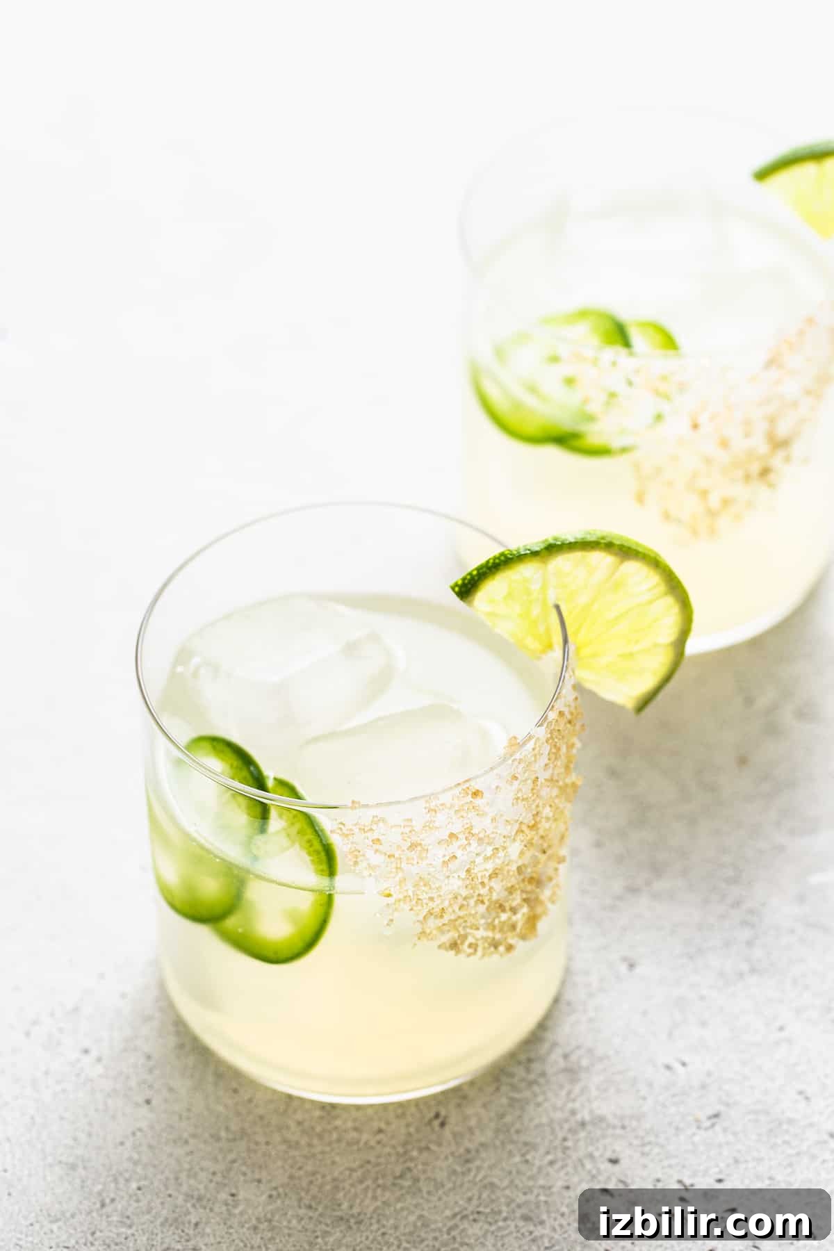 Spicy mezcal margarita in a glass with lime on the rim.