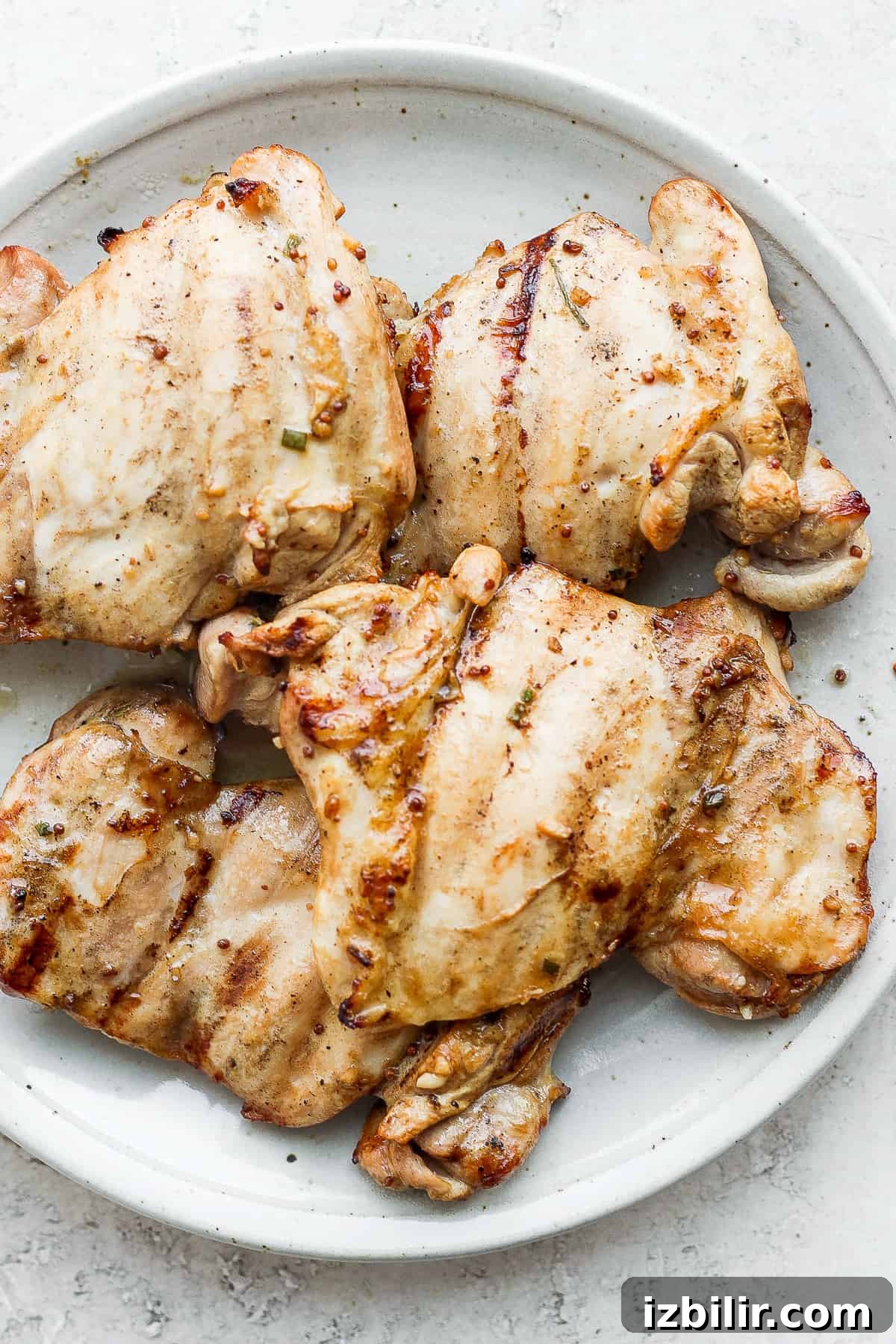 Grilled boneless chicken thighs with honey mustard marinade. Boneless chicken thighs on plate.