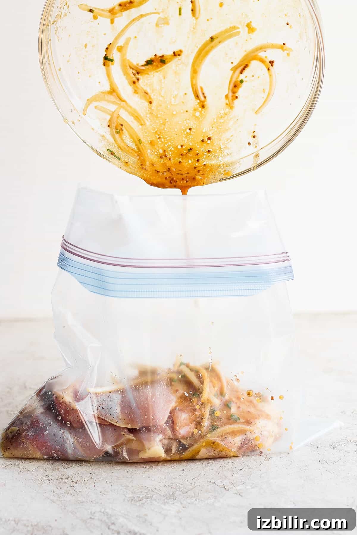 Savory Marinade for Juicy Chicken Thighs 4 Chicken thighs marinade being poured in a gallon size bag.