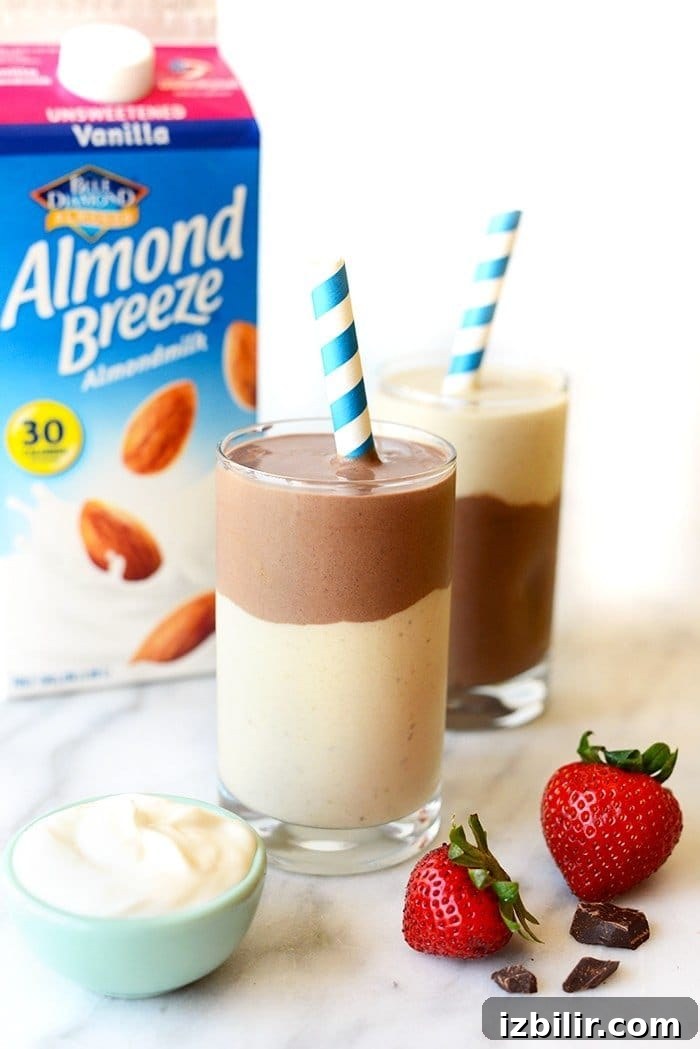 Chocolate banana protein smoothie layered chocolate banana smoothie with almond breeze carton in the background