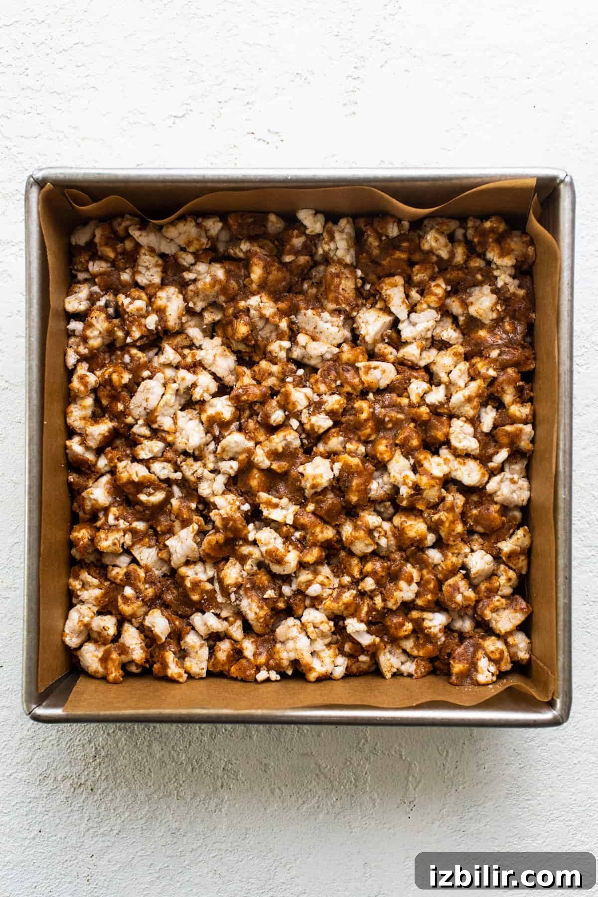 No-Bake Rice Cake Magic Bars Recipe with Chocolate and Nuts 4 Caramel popcorn in a pan on a white surface.