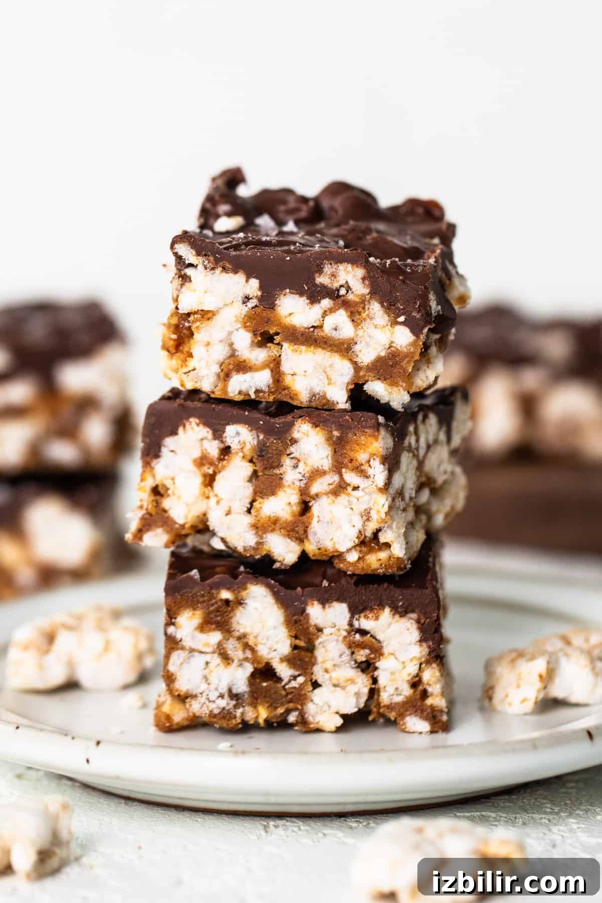 No-Bake Rice Cake Magic Bars Recipe with Chocolate and Nuts 5 A stack of chocolate graham cracker bars on a plate.