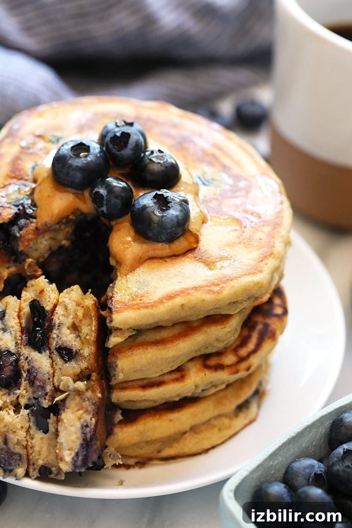 Close-up of a pancake being drizzled with syrup.