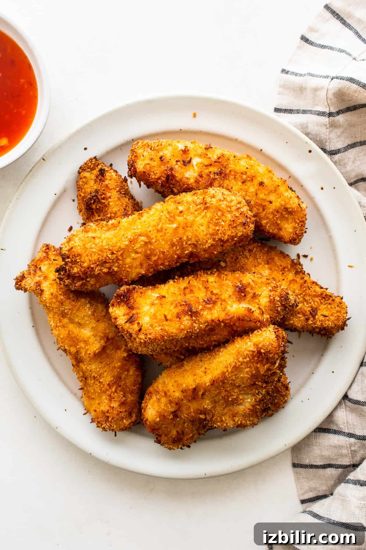 Crispy coconut chicken tenders on a plate.