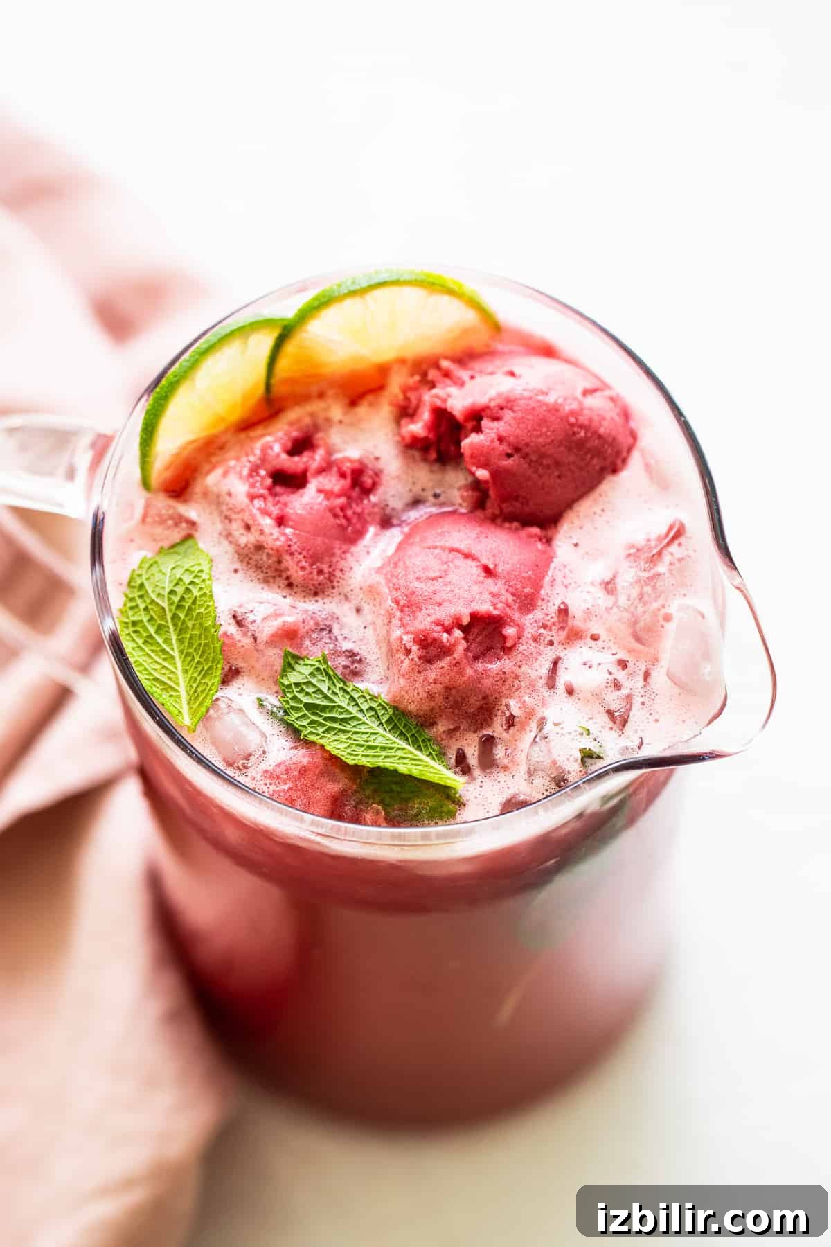 Looking for a summer cocktail to sip on? Try our summer punch made with fresh raspberry juice, vodka, mint, and a splash of ginger beer all served over sorbet. summer punch in pitcher with fresh mint.