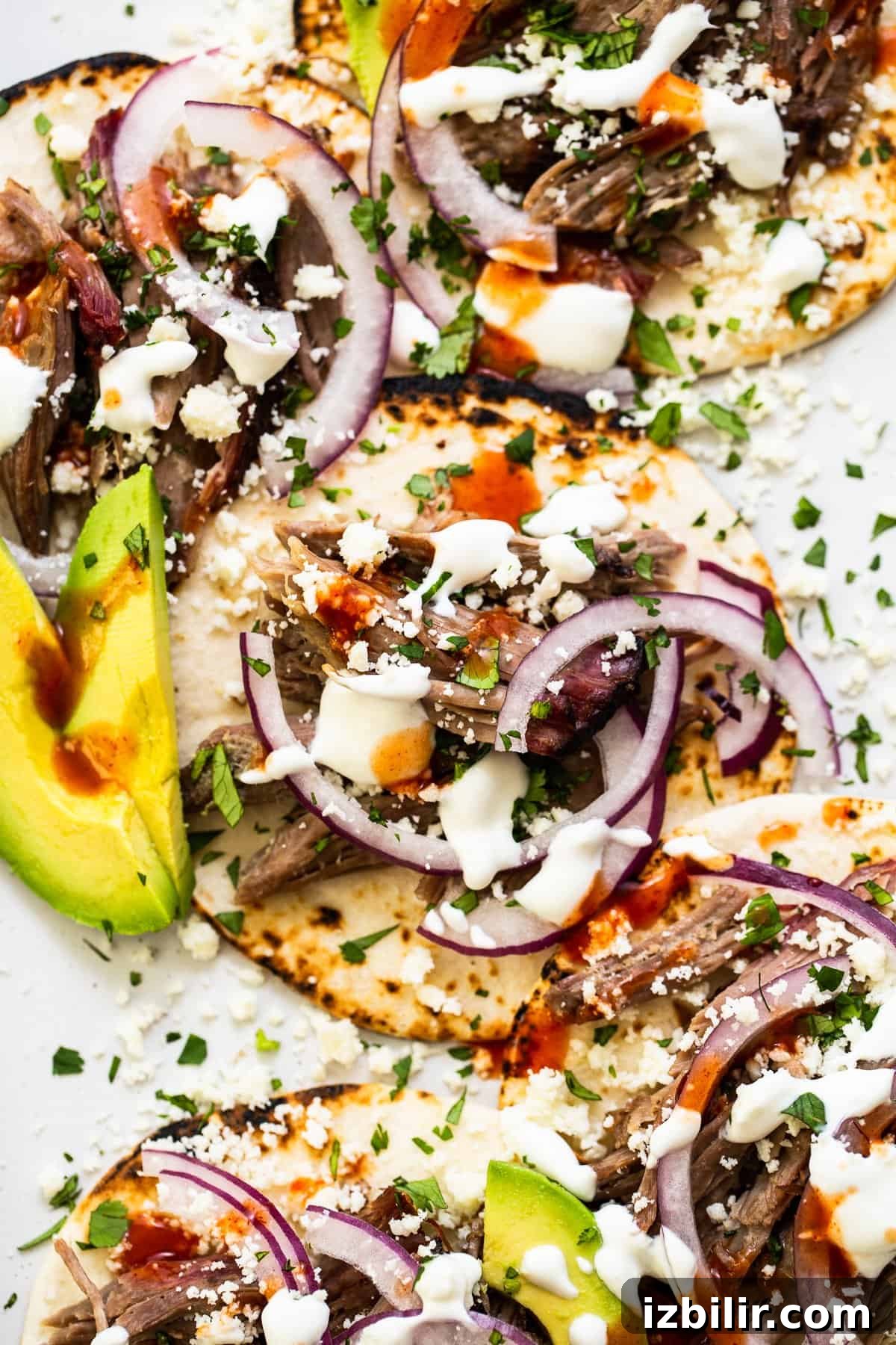 These smoked pulled pork tacos are made with our incredible, fall-off-the-bone smoked pork shoulder and all the best toppings. loaded smoked shredded pork tacos.
