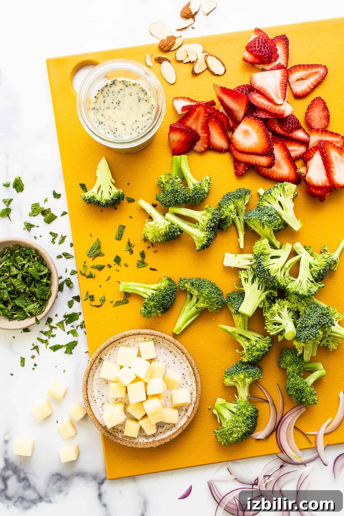 Fresh Strawberry Broccoli Salad Recipe with Poppy Seed Dressing 3 Ingredients for strawberry broccoli salad on a cutting board.