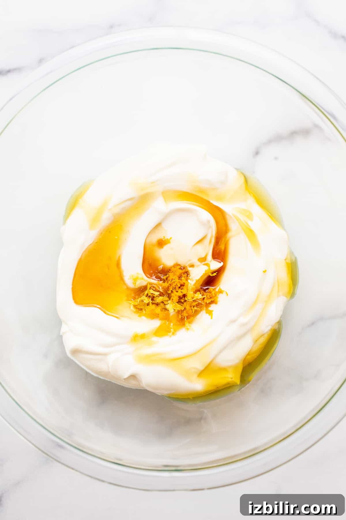 Greek yogurt with honey and lemon zest in a bowl.