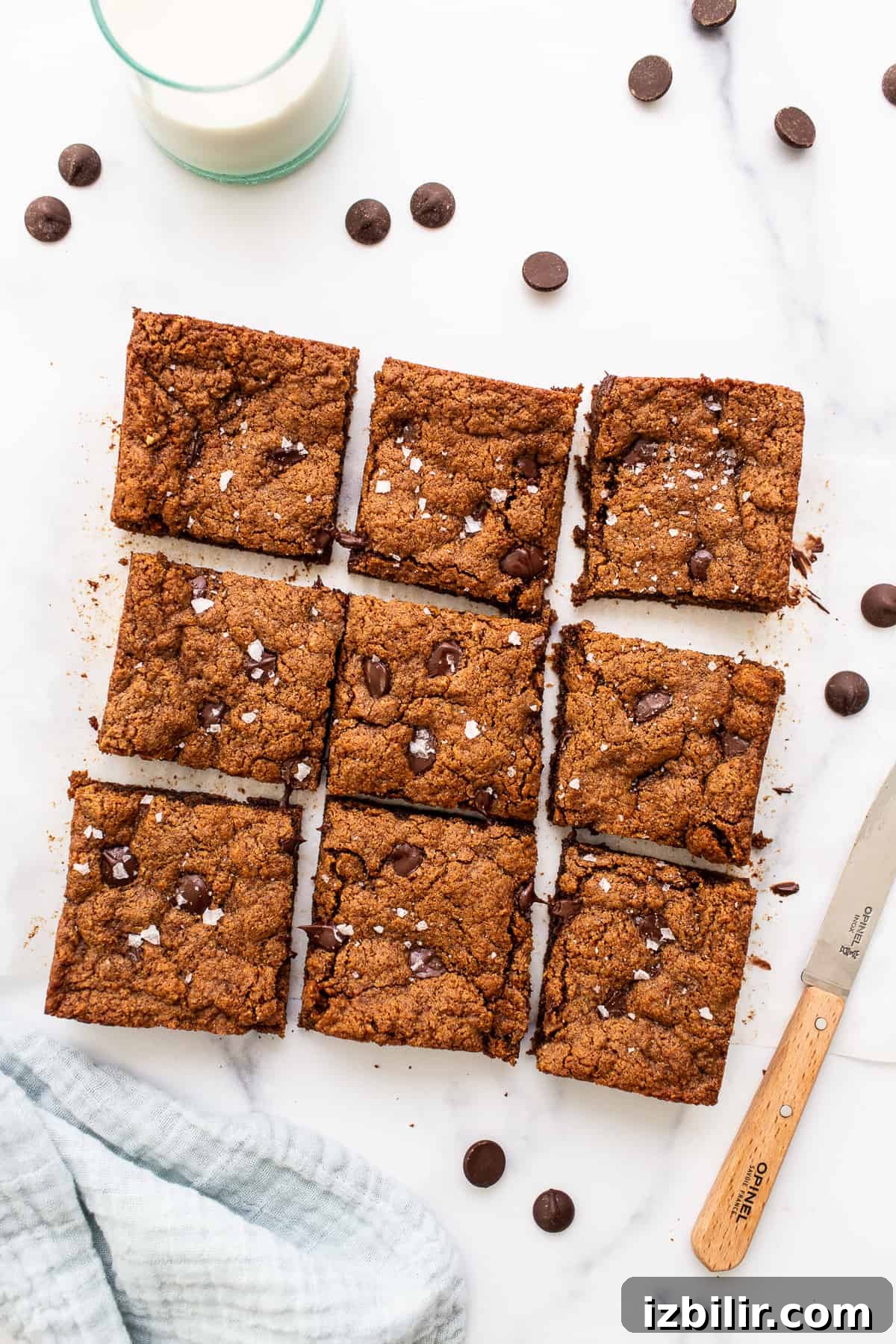 These grain-free chocolate chip cookie bars are made with almond butter, coconut flour, coconut sugar, eggs, and dark chocolate chips! sliced cookie bars on countertop.