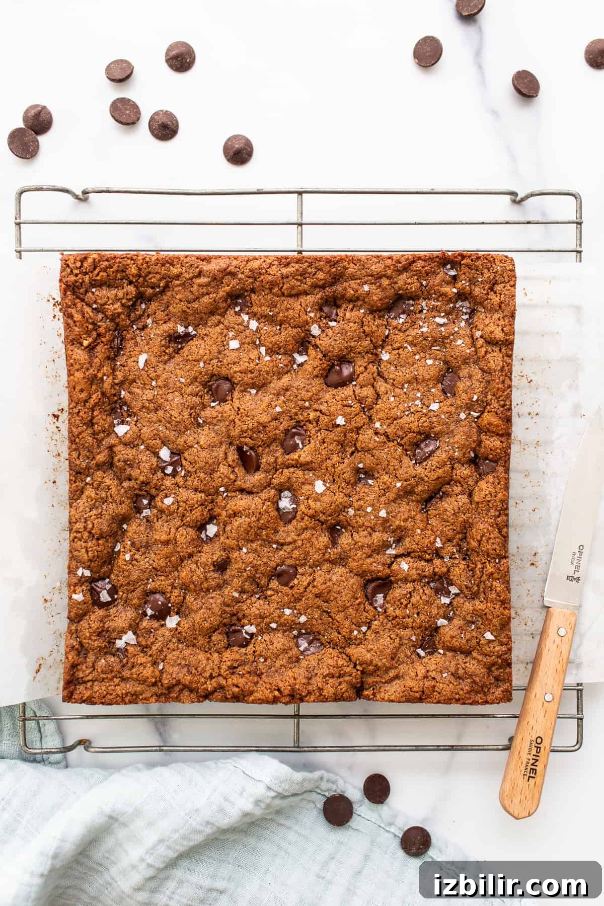 Make our flourless almond butter chocolate chip cookie bars for a delicious treat made with wholesome ingredients! unsliced cookie bars on drying rack.