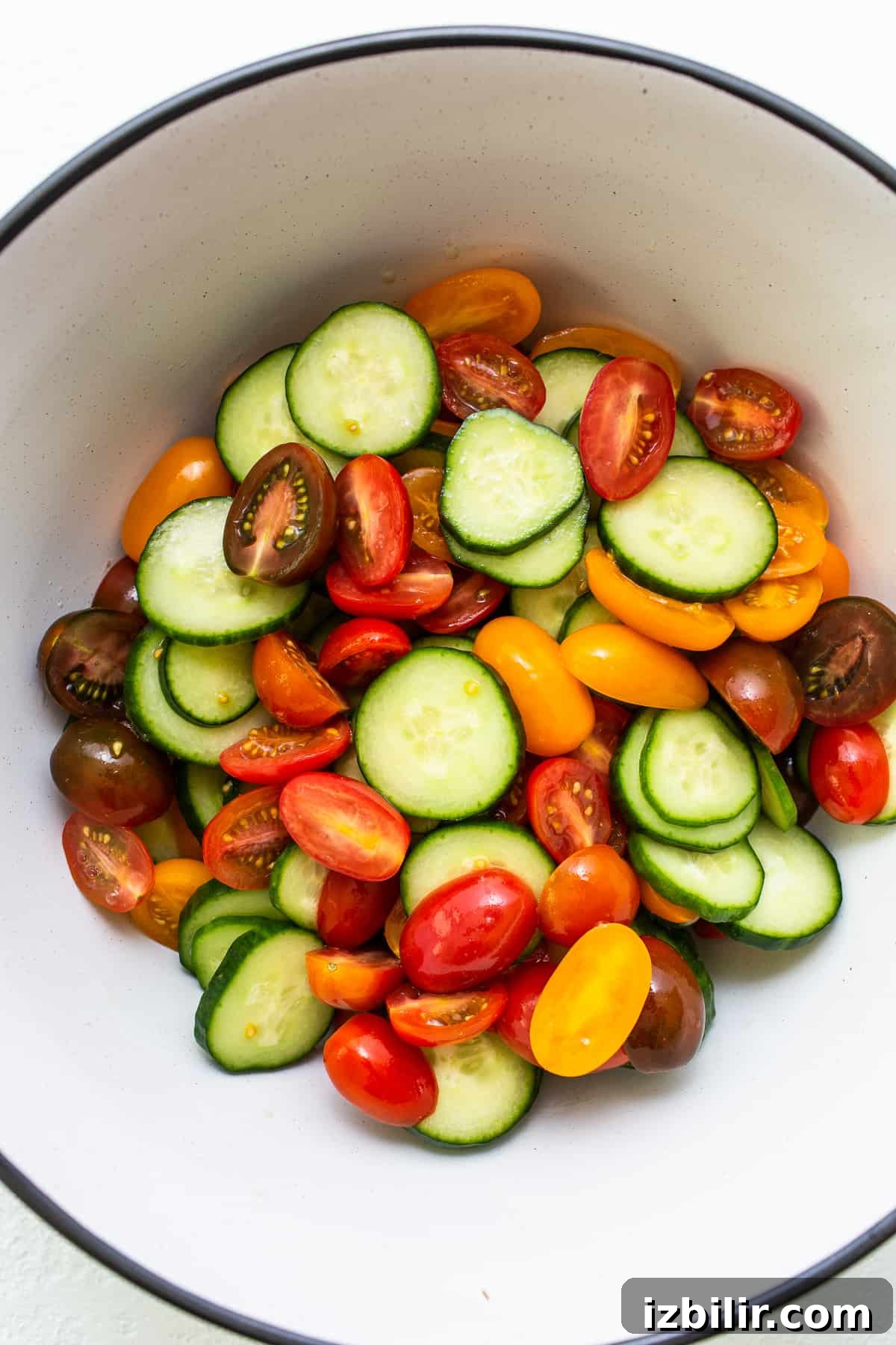 Fresh Cucumber and Tomato Salad with Herbs 4 Tomatoes and cucumbers in a mixing bowl.