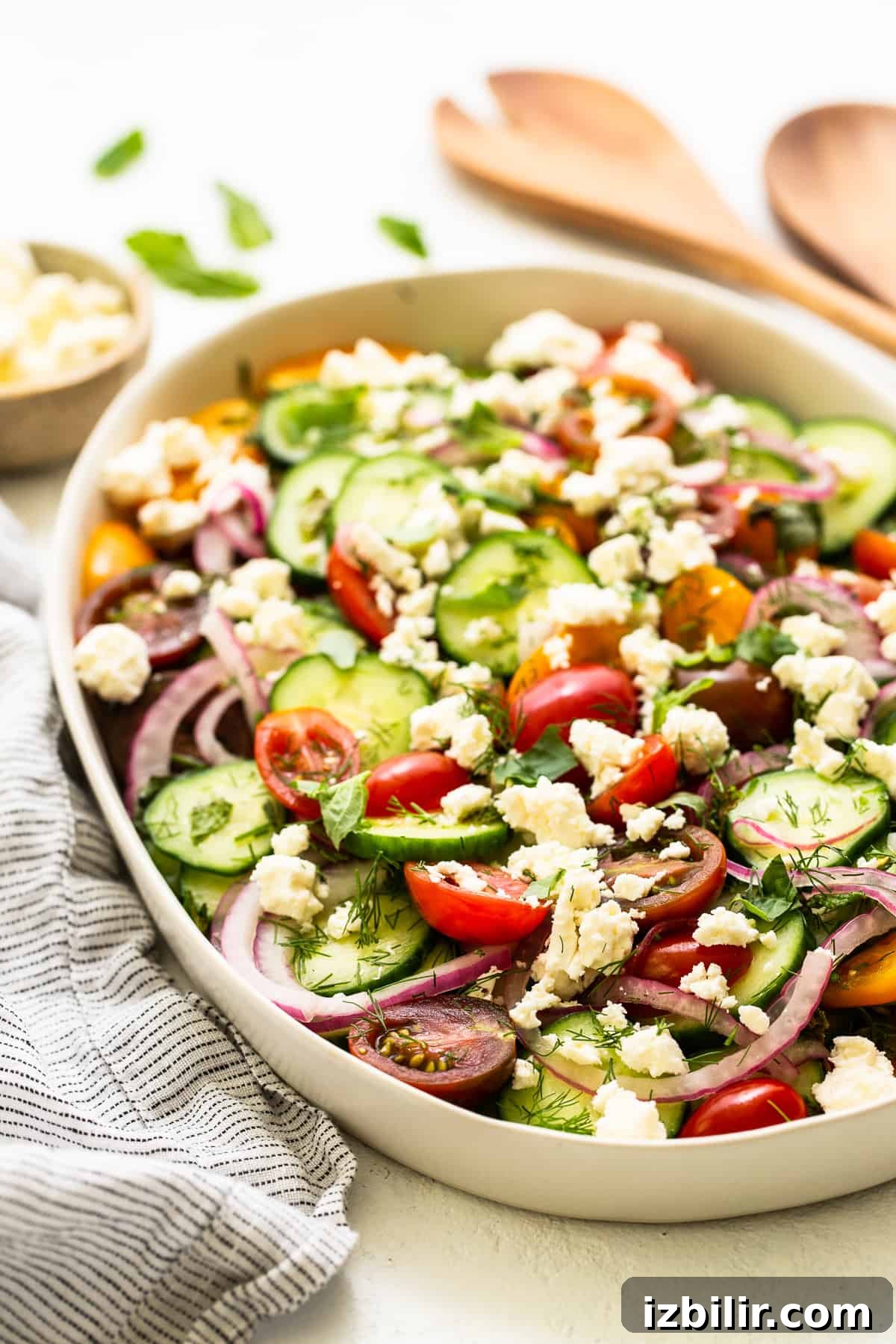 Fresh Cucumber and Tomato Salad with Herbs 6 Cucumber tomato salad in a bowl topped with feta.