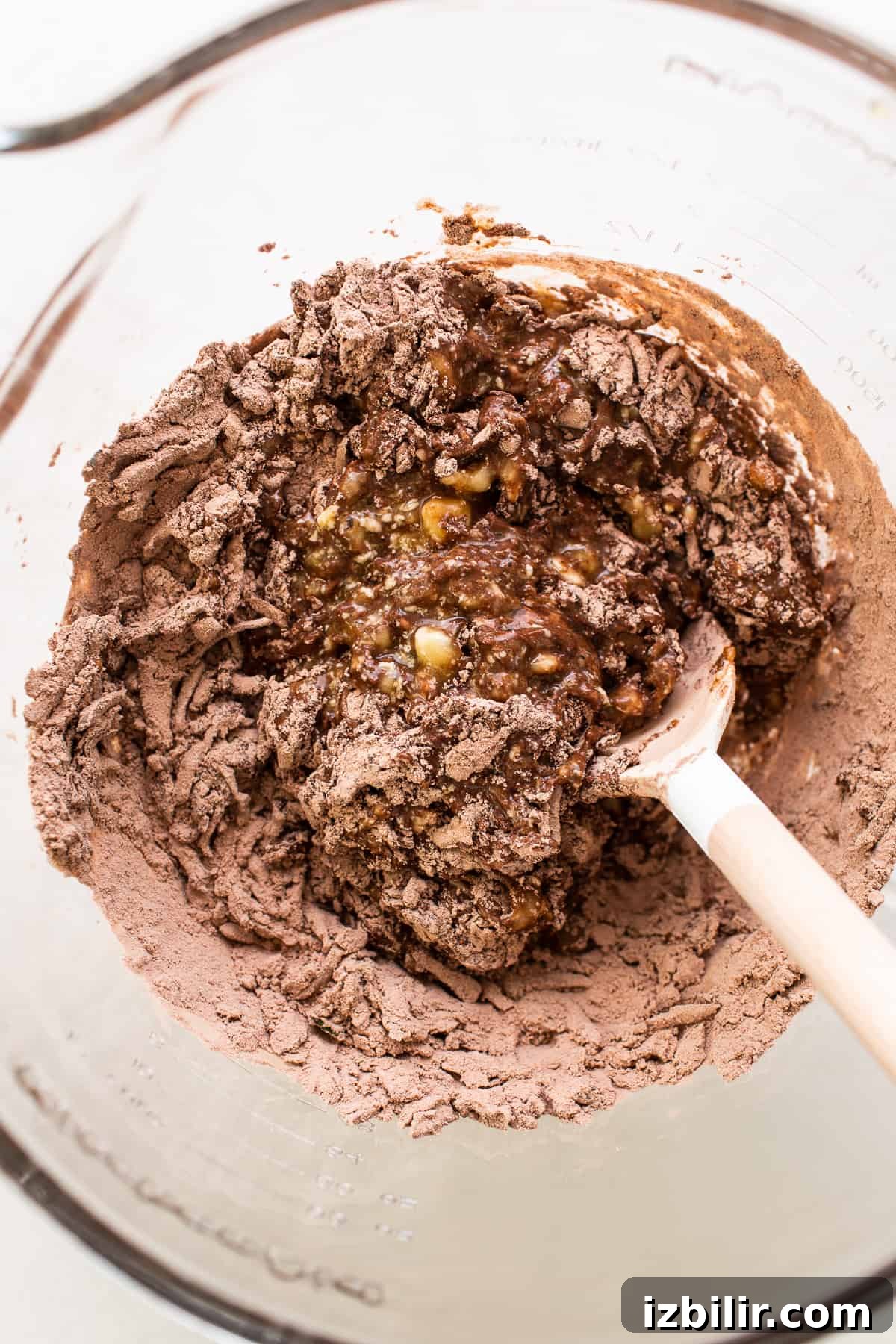Dry and wet ingredients combined in a bowl for chocolate zucchini bread.