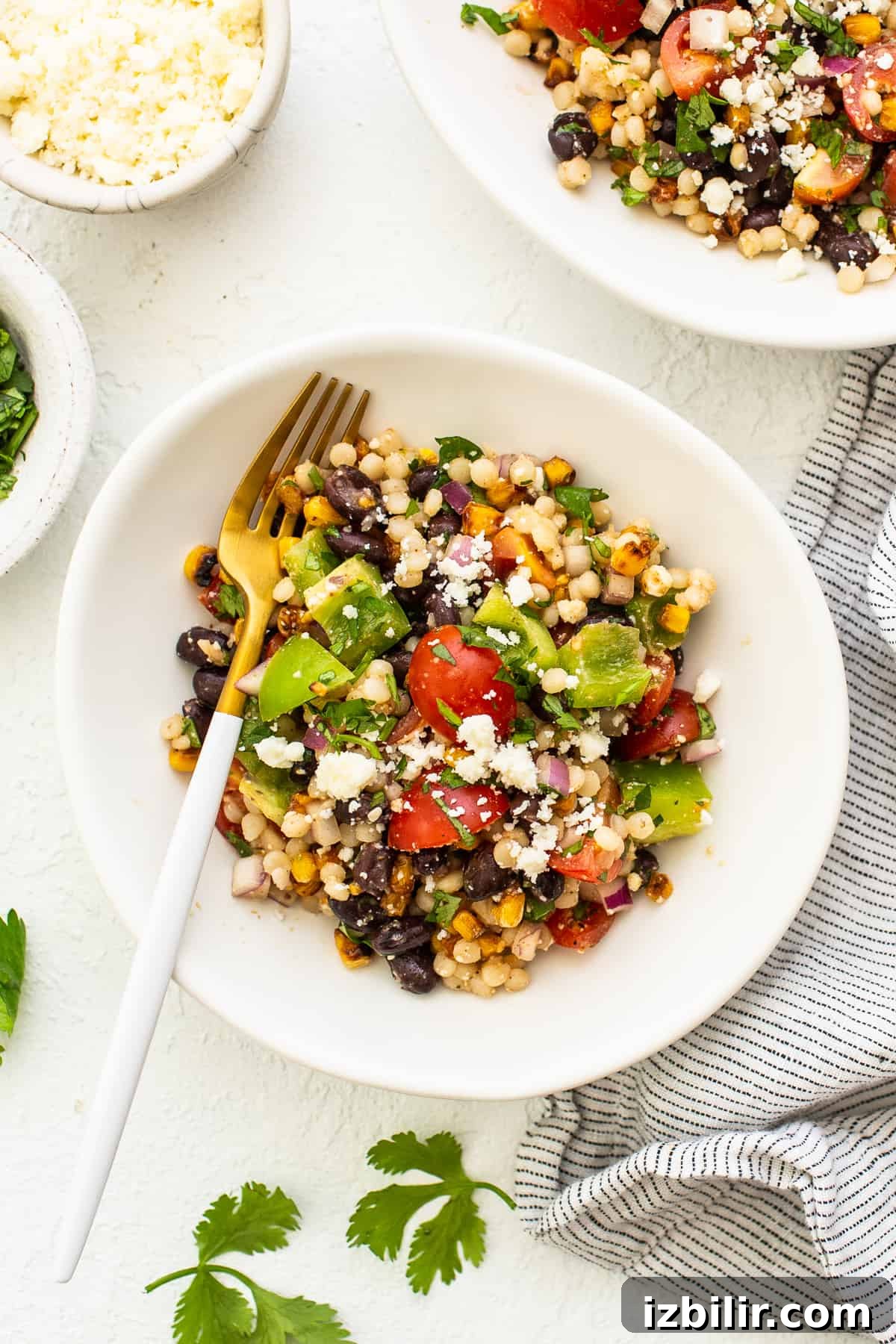 couscous salad in bowl with fork.