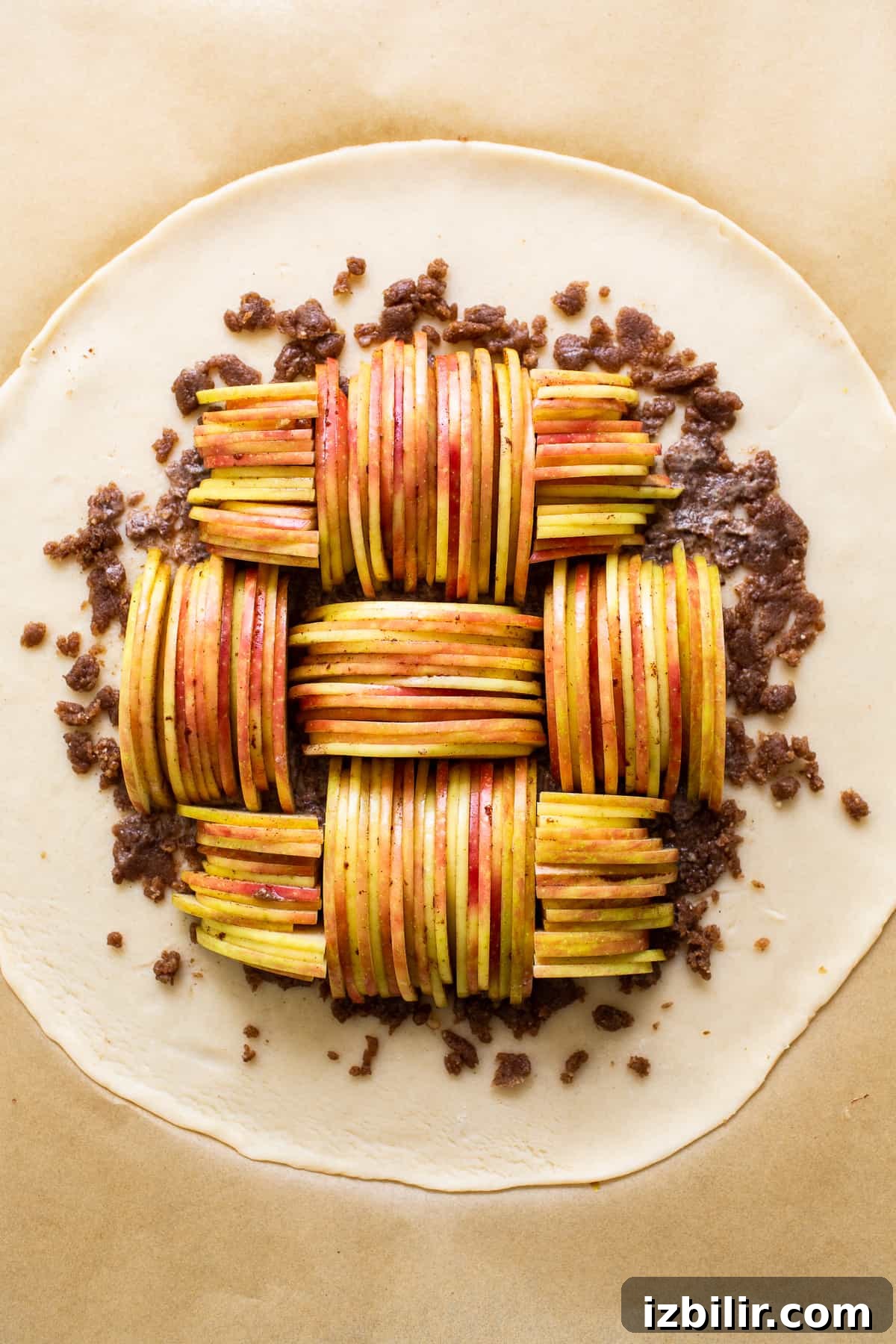 Arrange apples neatly for an attractive galette design. Uncooked apple galette on pie crust.