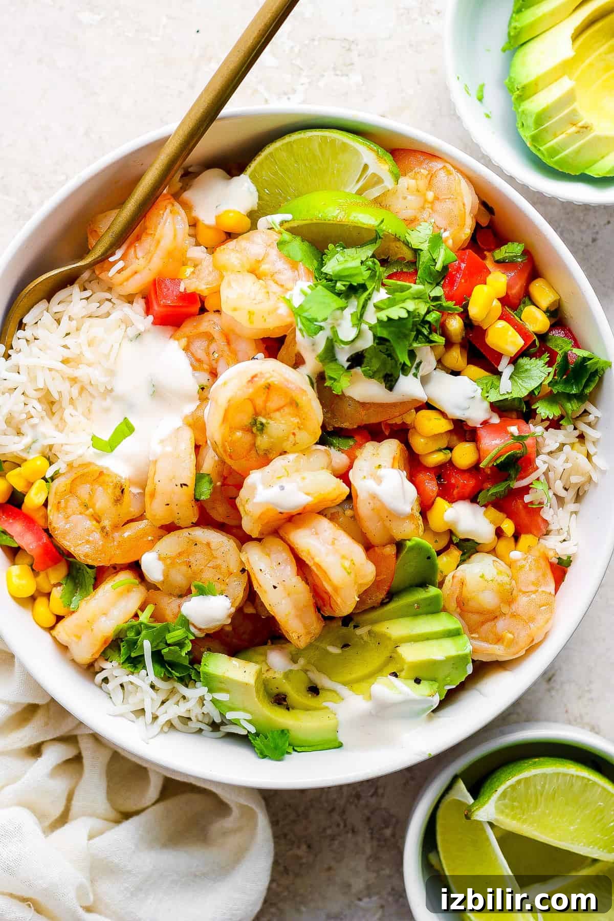Cilantro Lime Shrimp Rice Bowls with Avocado 2 A white bowl with shrimp, corn and avocado.