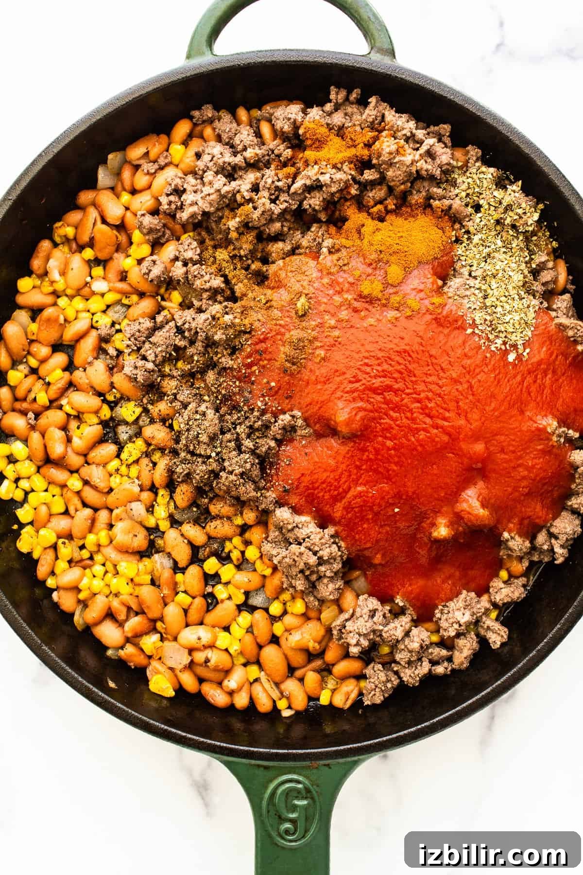 Ingredients for stuffed pepper filling in a cast iron skillet.