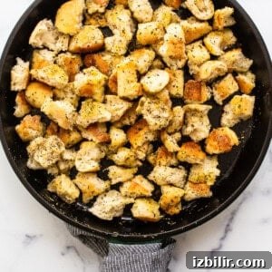 Pan frying croutons in a cast iron skillet.