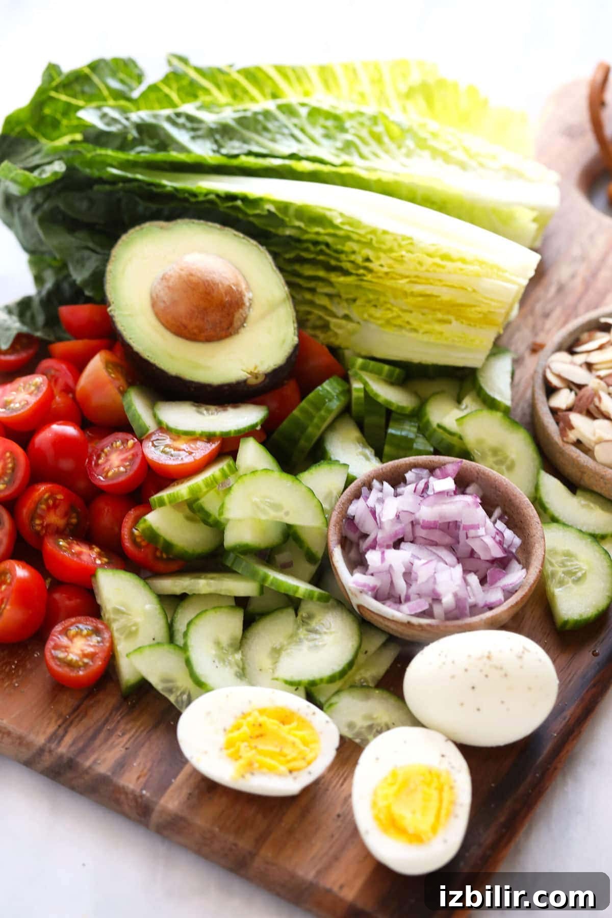 This crunchy bacon wrapped chicken salad is packed with veggies, hard boiled eggs, homemade ranch dressing, and flavorful bacon wrapped chicken! lettuce and veggies on cutting board
