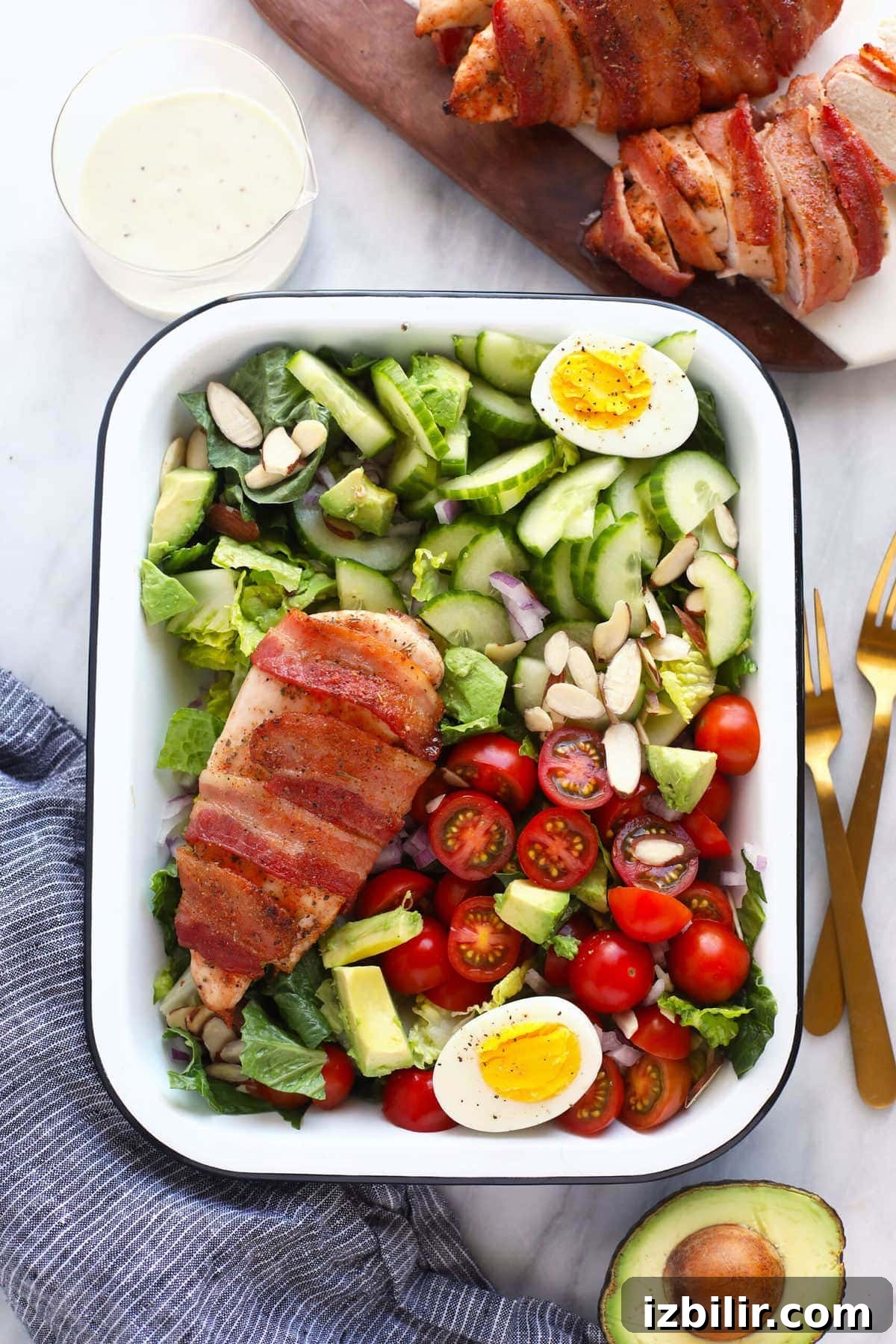 This crunchy bacon wrapped chicken salad is packed with veggies, hard boiled eggs, homemade ranch dressing, and flavorful bacon wrapped chicken! chicken salad in dish with 2 forks