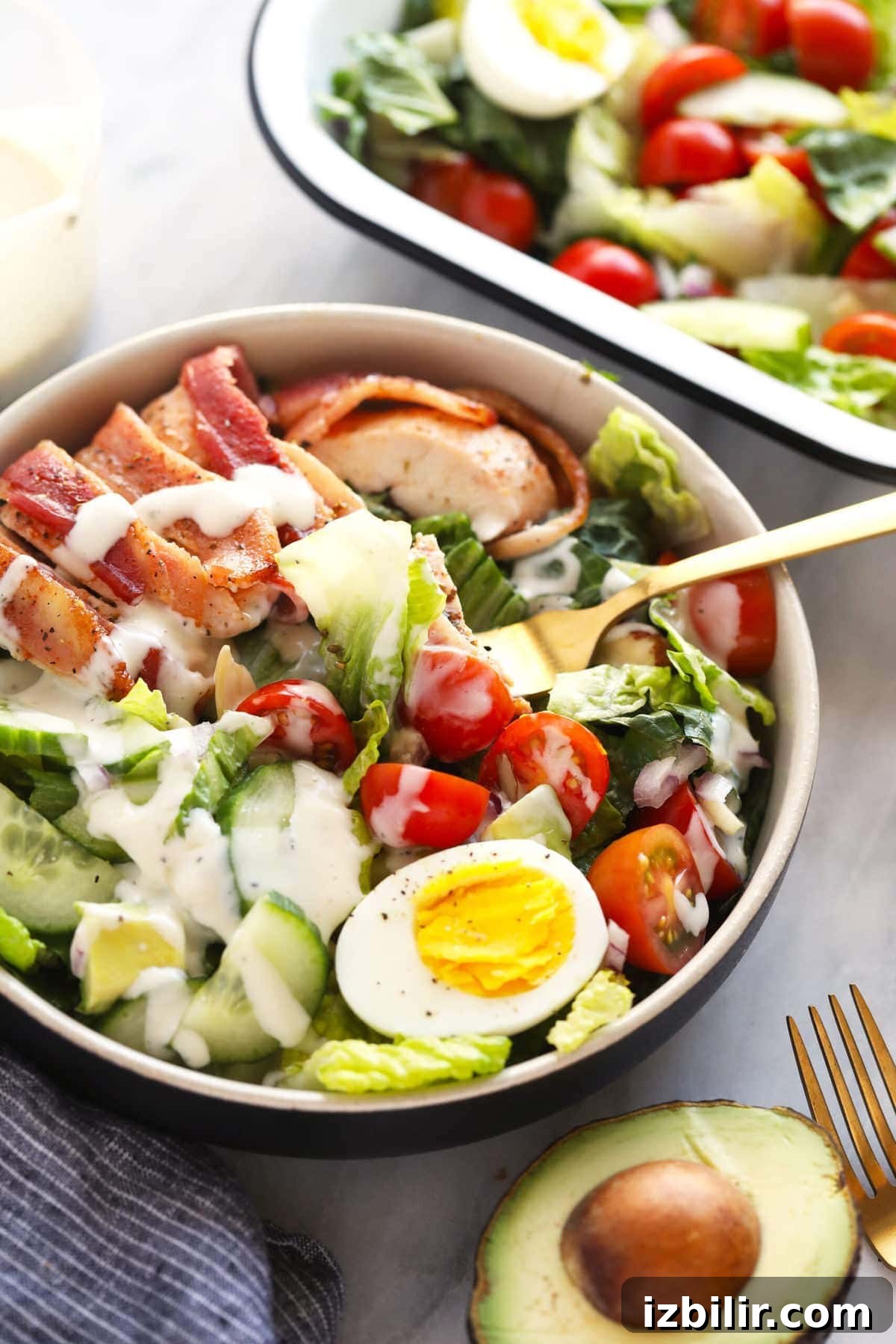 This crunchy bacon wrapped chicken salad is packed with veggies, hard boiled eggs, homemade ranch dressing, and flavorful bacon wrapped chicken! fork in chicken salad