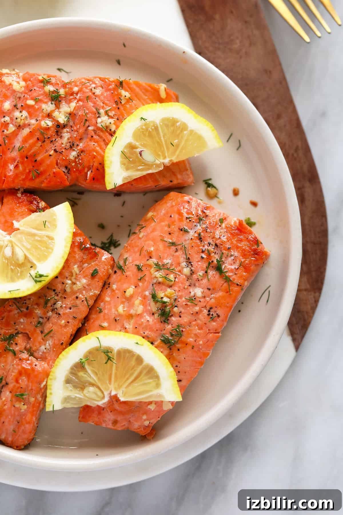 Pan Seared Salmon with Crispy Skin and Lemon Butter 5 Seared salmon on a plate with lemon wedges