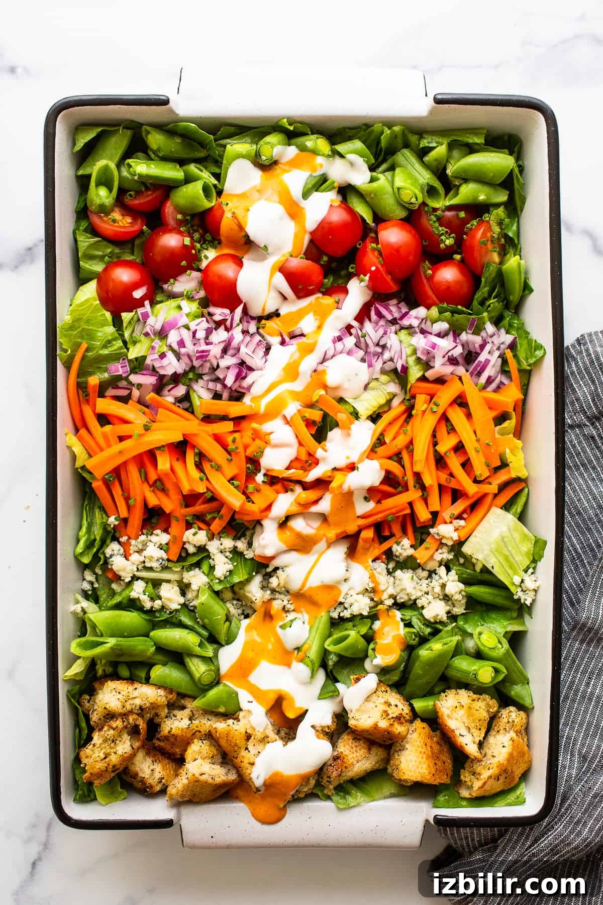 Ultimate garden salad Garden salad in a serving dish topped with salad dressing.