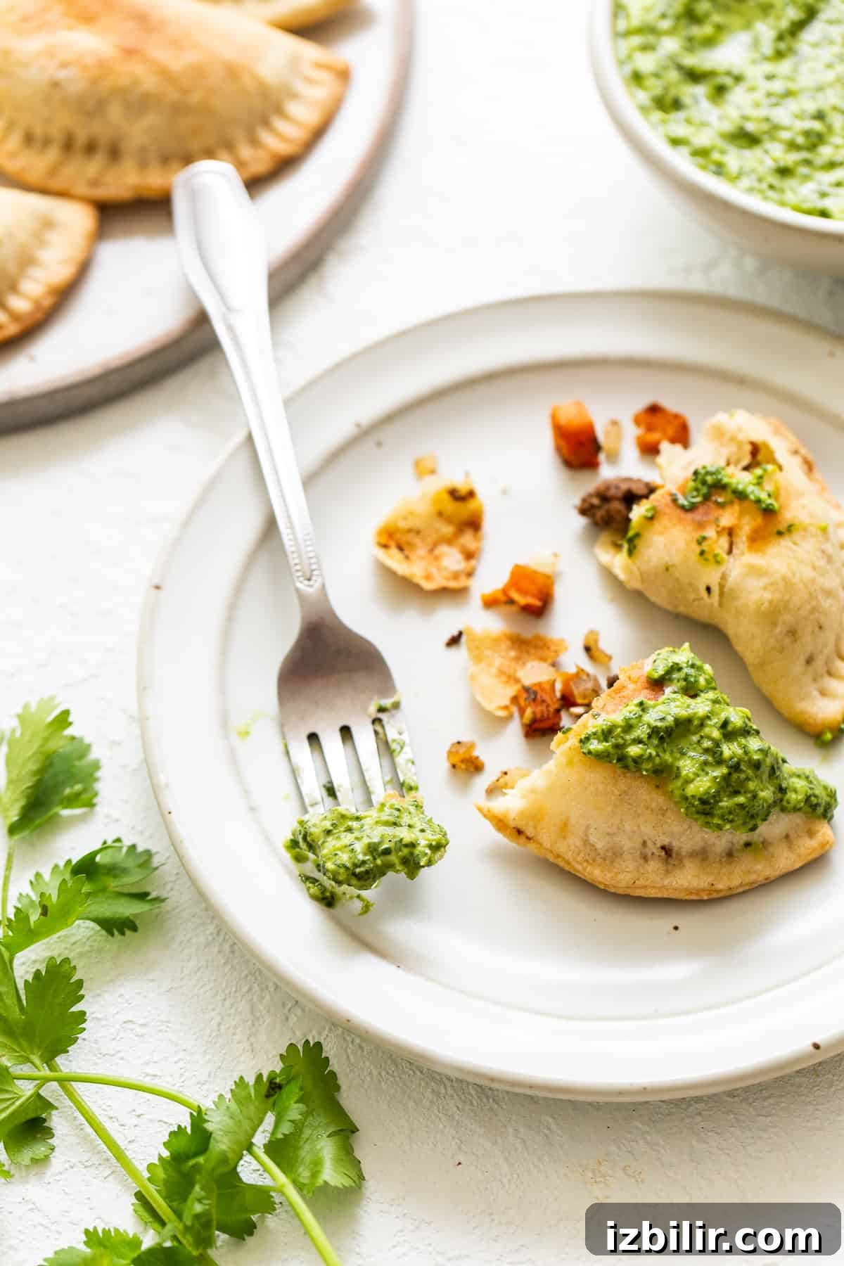 Empanadas with green sauce on top.