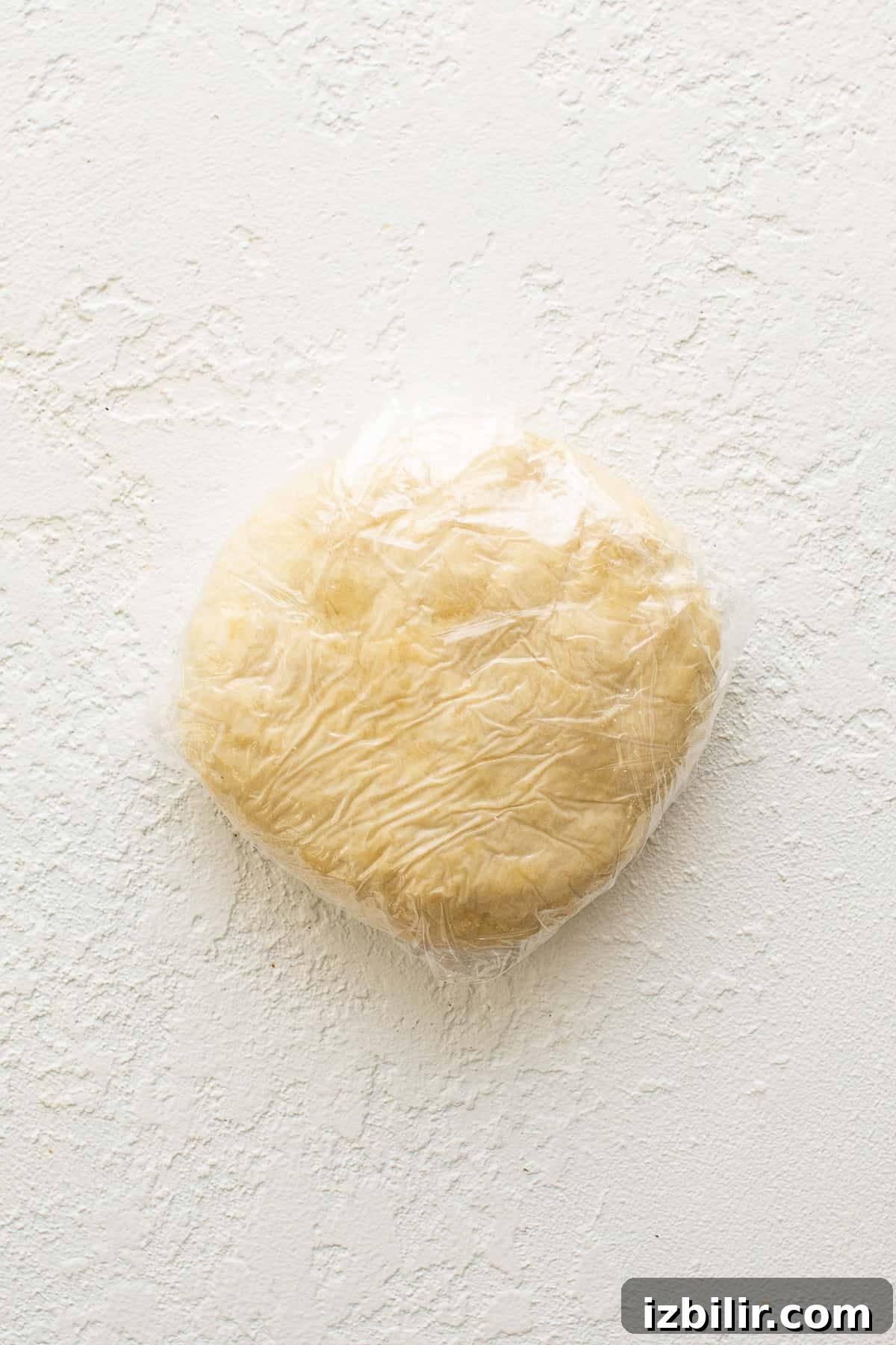 Empanada dough wrapped in plastic wrap.